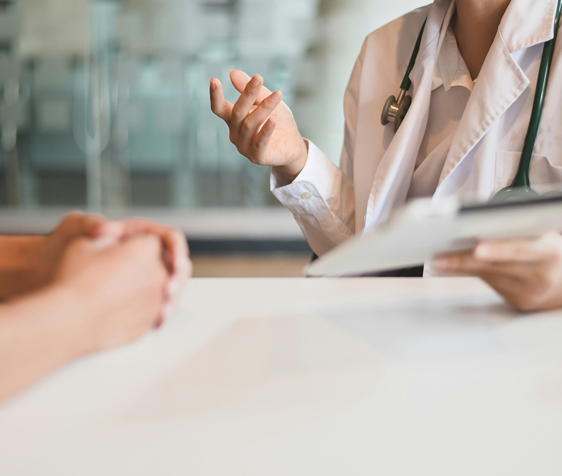 Doctor with clipboard talking to patient